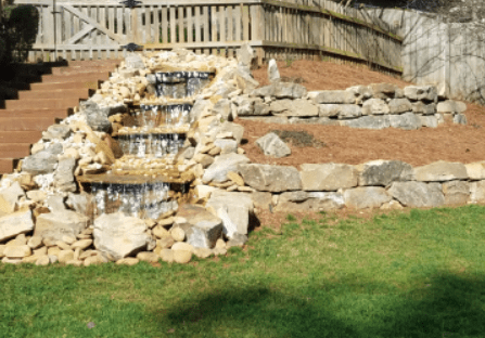 A backyard with rocks and water features