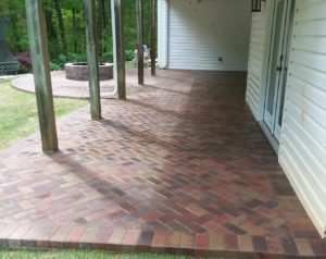 A brick patio with a tree in the middle of it