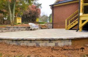 A patio with steps and stairs leading to the back yard.