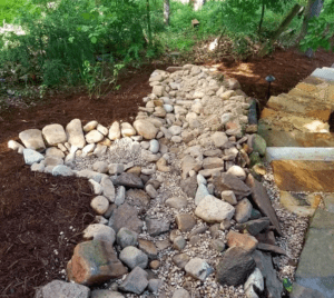 A garden with rocks and mulch in the middle of it.