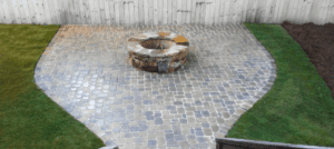 A fire pit sitting on top of a brick patio.