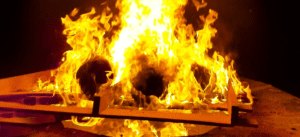 A fire is burning in the middle of a fireplace.