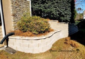 A concrete wall outside a house with trees in the inside