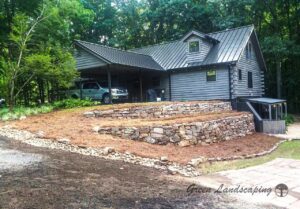 A wooden house in gray color with a car parked.